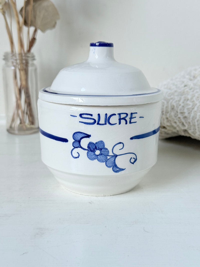 Vintage French blue and white studio pottery sugar bowl with lid, photographed on a white surface.
