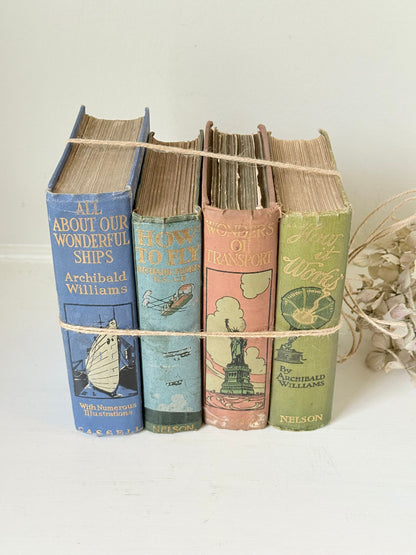 Vintage decorative book bundle in green, blue, and coral with printed lettering, tied with twine, photographed on a white surface