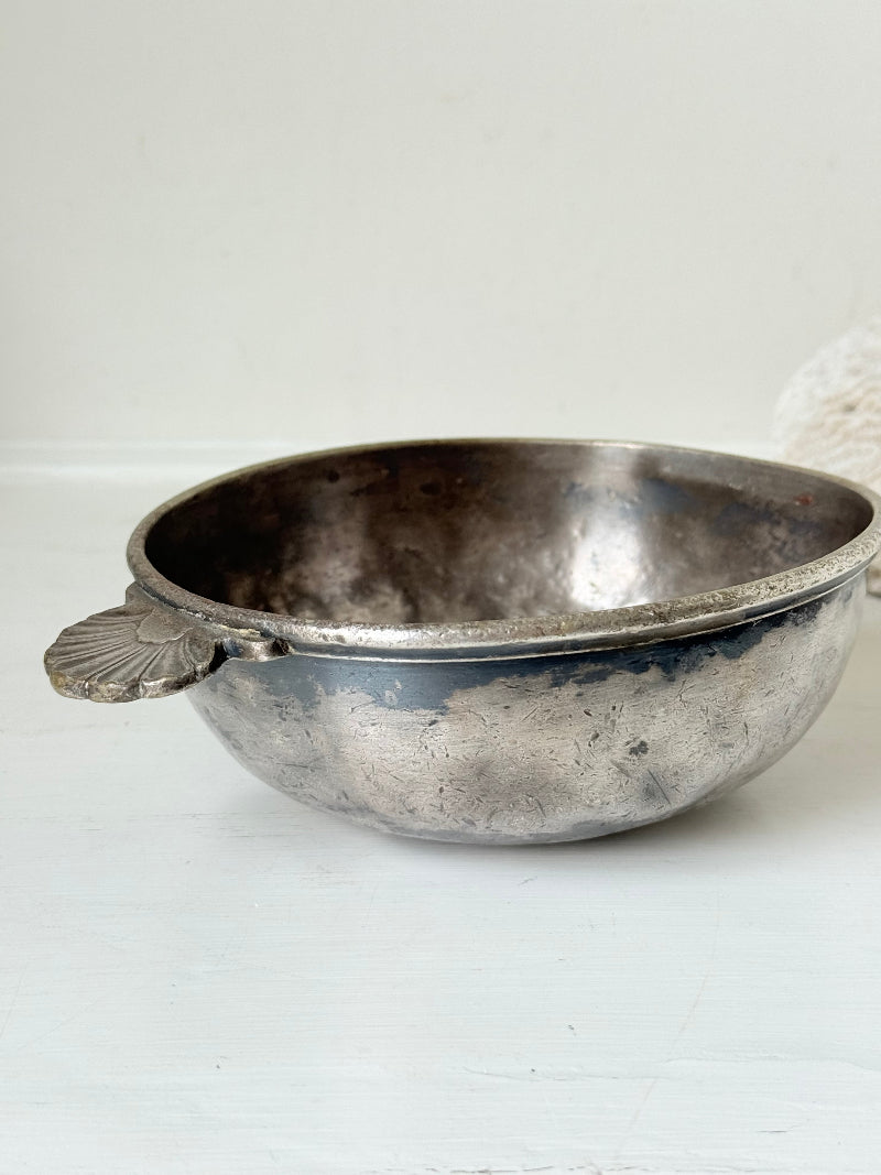 Antique Christofle silver plate bowl with decorative handle, photographed on a white surface.