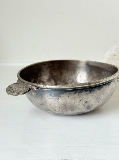 Antique Christofle silver plate bowl with decorative handle, photographed on a white surface.