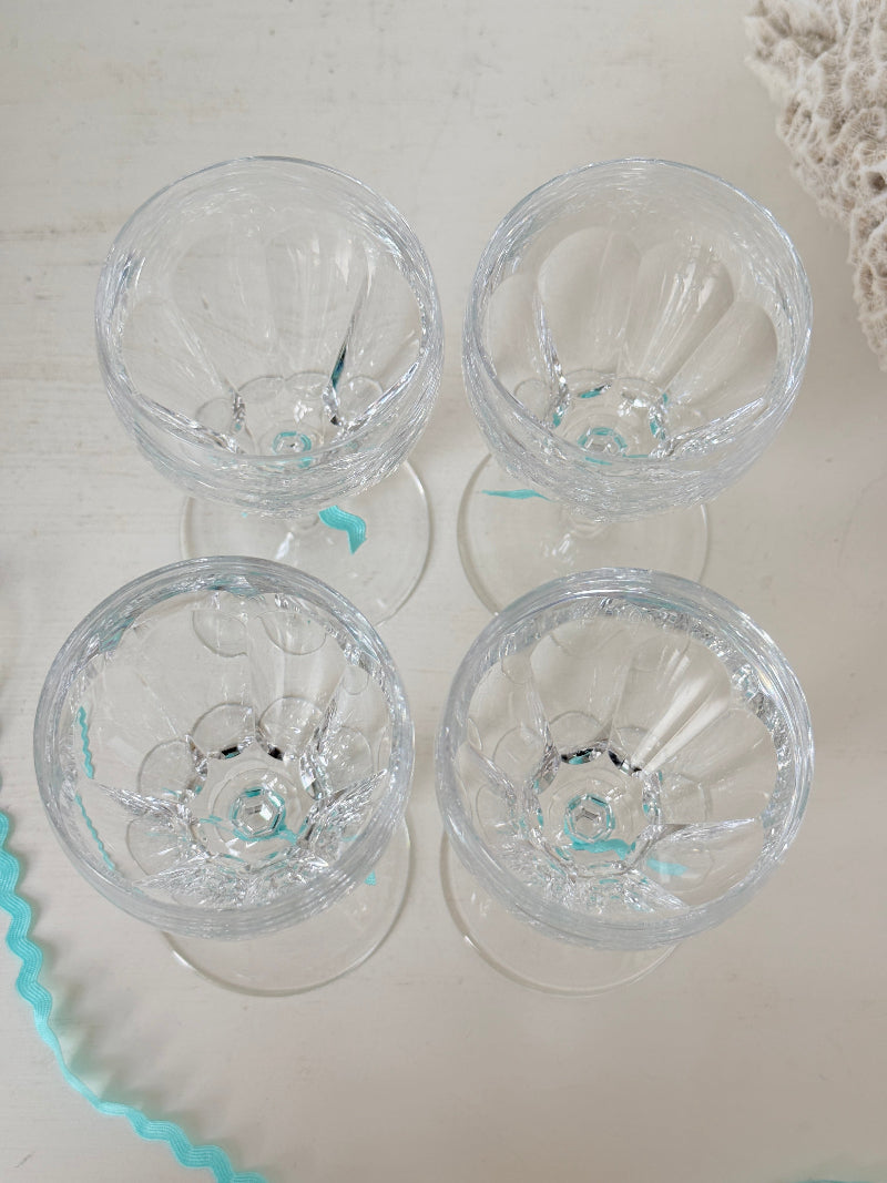 Set of four vintage cut crystal aperitif glasses with faceted bowls, photographed on a white surface