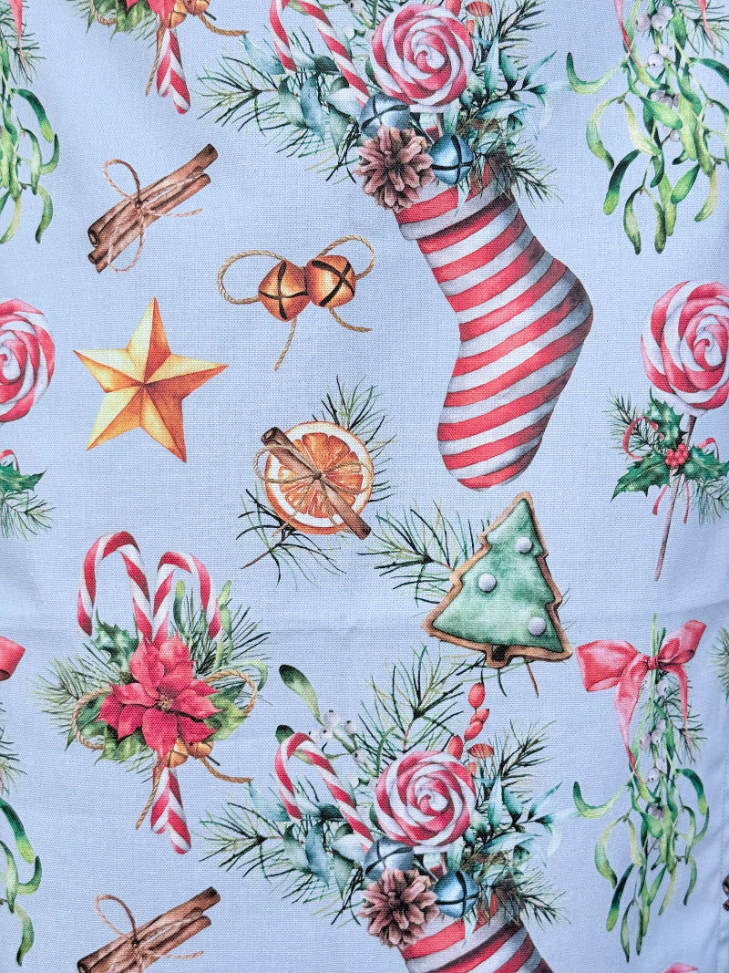Blue Loft Christmas cotton tea towel with red striped stocking and festive motif pattern photographed on a white worktop.