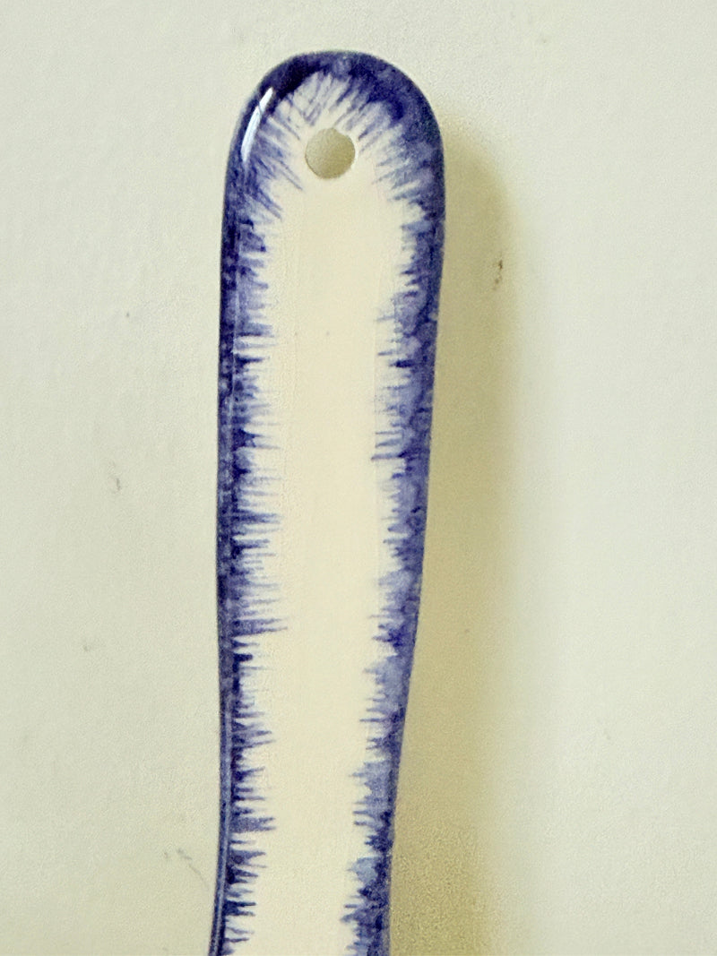 French Quimper faience handled wall dish with Petit Breton figure and blue rim, photographed on a white surface