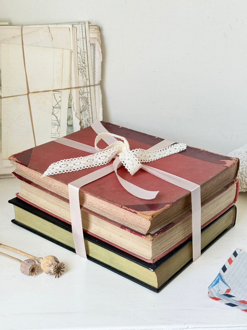 Large vintage decorative book bundle with burgundy cream and green hardback covers tied with ribbon for interior styling