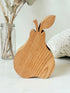 Vintage wooden pear sculpture in natural grain photographed on a white surface.