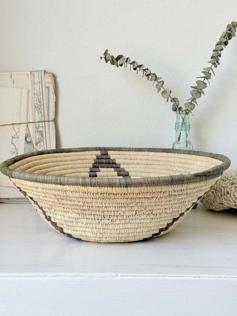 Large hand woven coiled basket with three point star pattern, natural fibre and dark geometric detail for wall or table styling