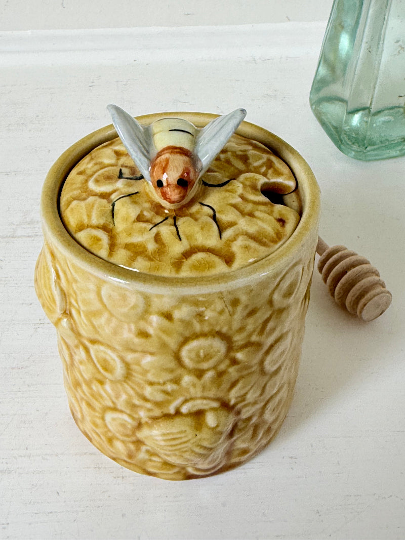 Secla pottery honey jar with lid, bee motif, and wooden honey spoon, made in Portugal, photographed on a white surface