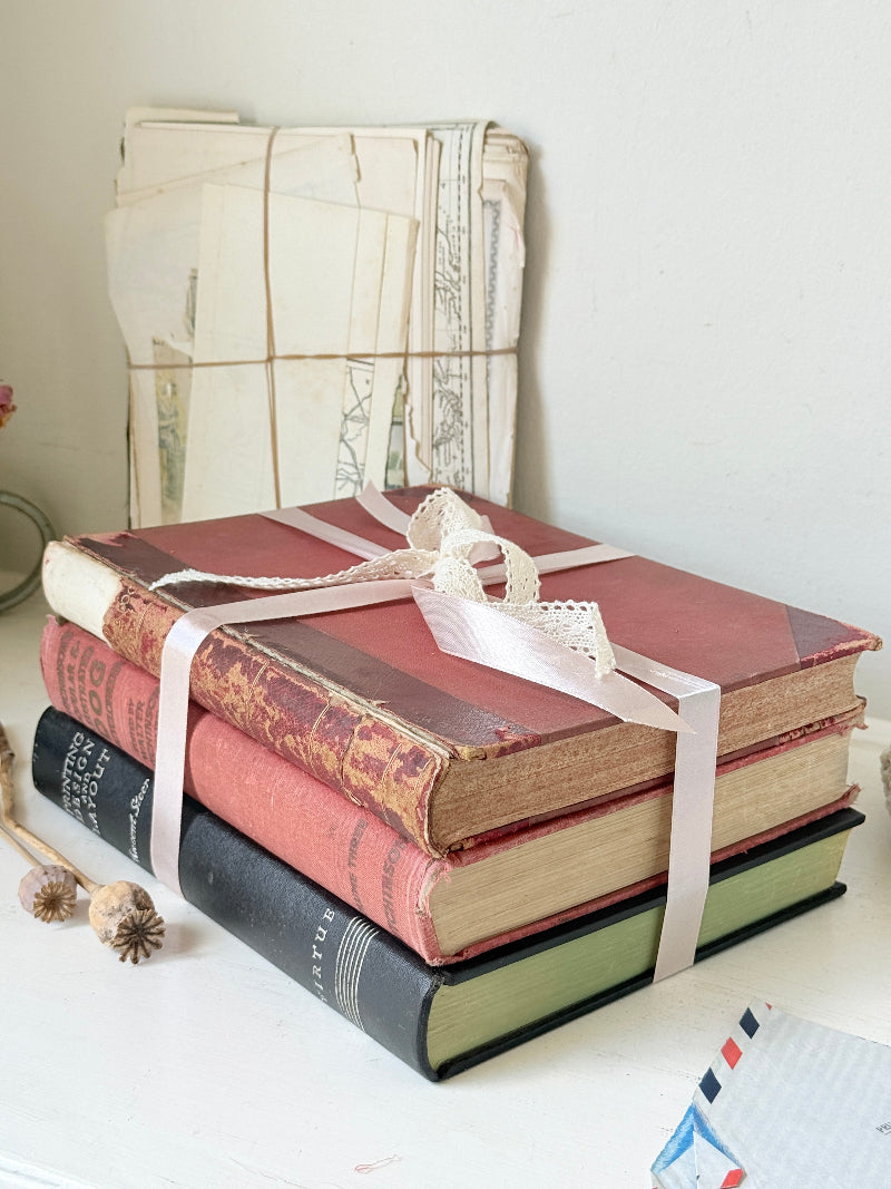 Large vintage decorative book bundle with burgundy cream and green hardback covers tied with ribbon for interior styling