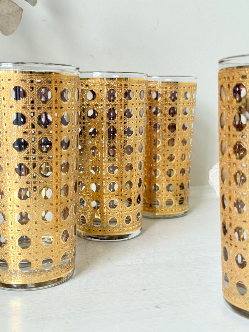 Set of 4 vintage gold rattan effect glasses with pierced lattice sleeves, photographed on a white surface