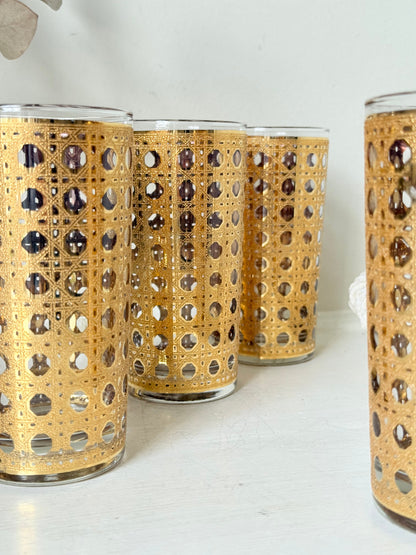 Set of 4 vintage gold rattan effect glasses with pierced lattice sleeves, photographed on a white surface