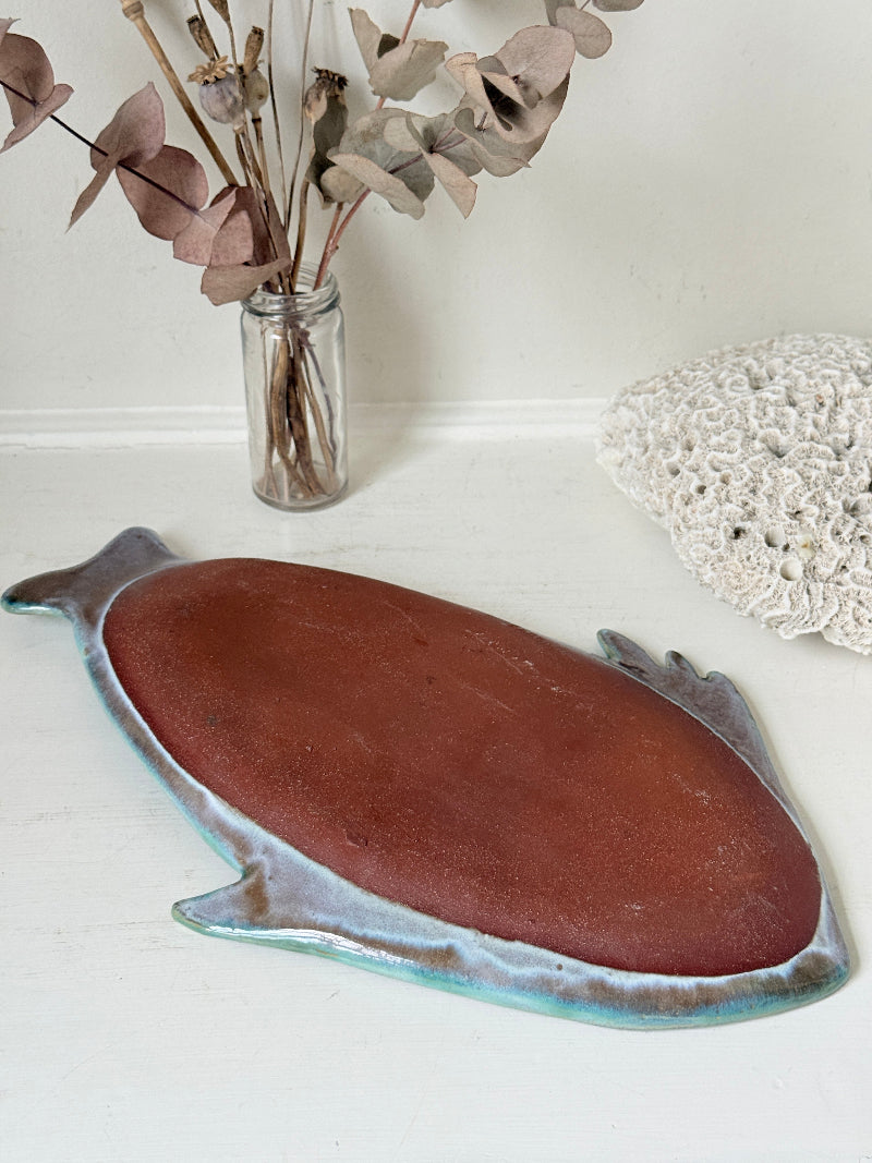 Barbados studio pottery fish platter in turquoise and sea green glaze photographed on a white surface