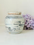 Antique Chinese ginger jar with blue brushwork, photographed on a white surface with vintage books and hydrangeas

