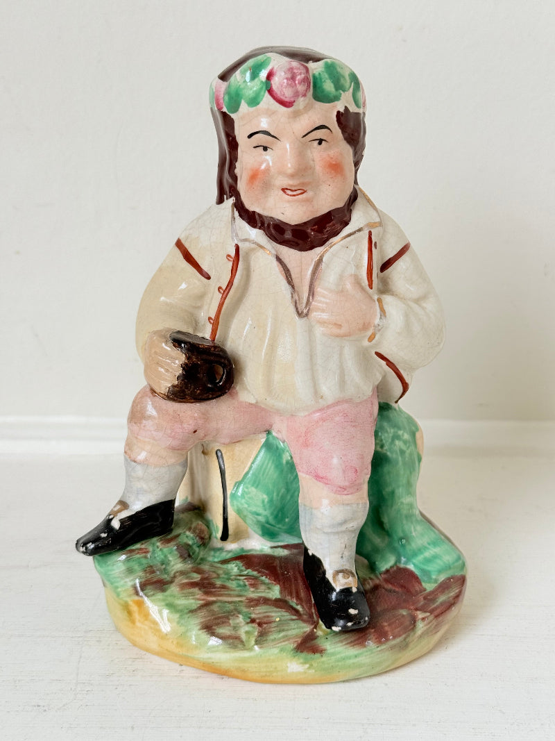 Bacchus antique Staffordshire pottery figure with painted details, photographed on a white surface.