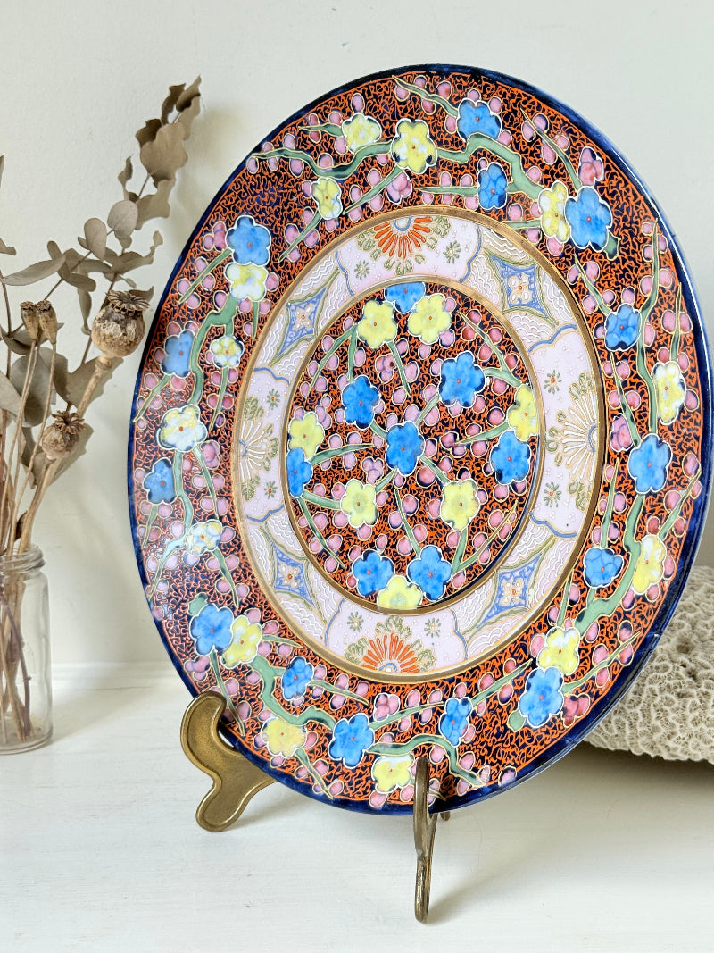 Antique Japanese Aoki Brothers platter with colourful Imari style floral pattern photographed on a white surface