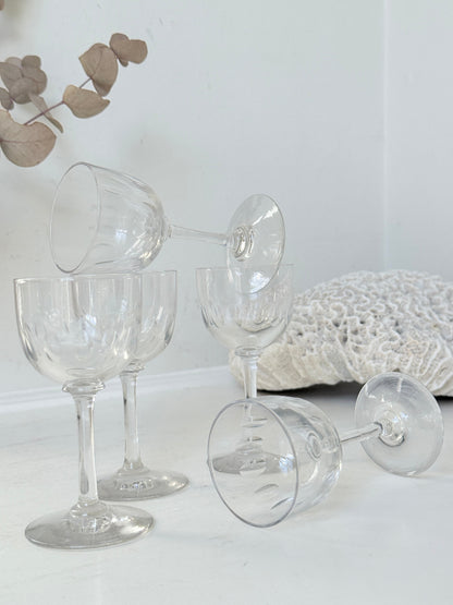 Set of 5 vintage clear glass liqueur glasses with small stems photographed on a white surface