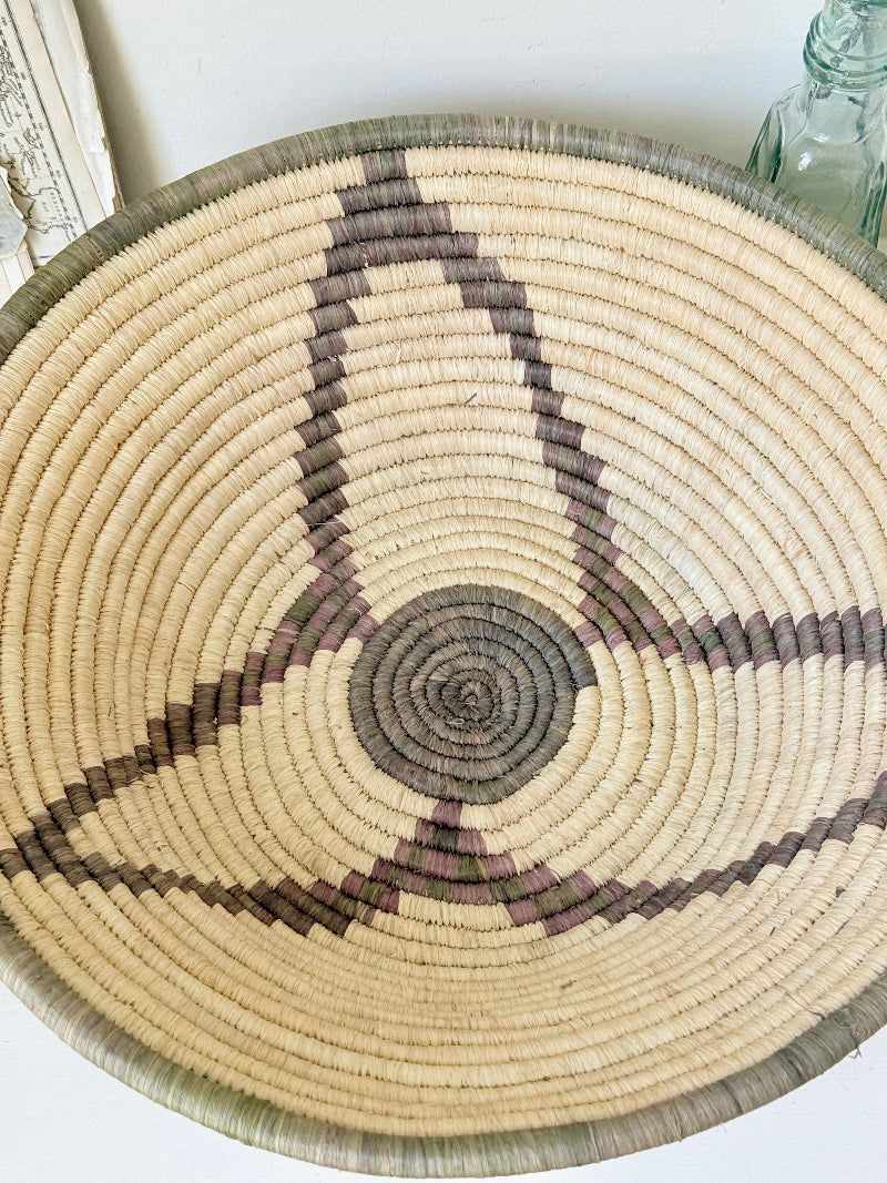 Large hand woven coiled basket with three point star pattern, natural fibre and dark geometric detail for wall or table styling