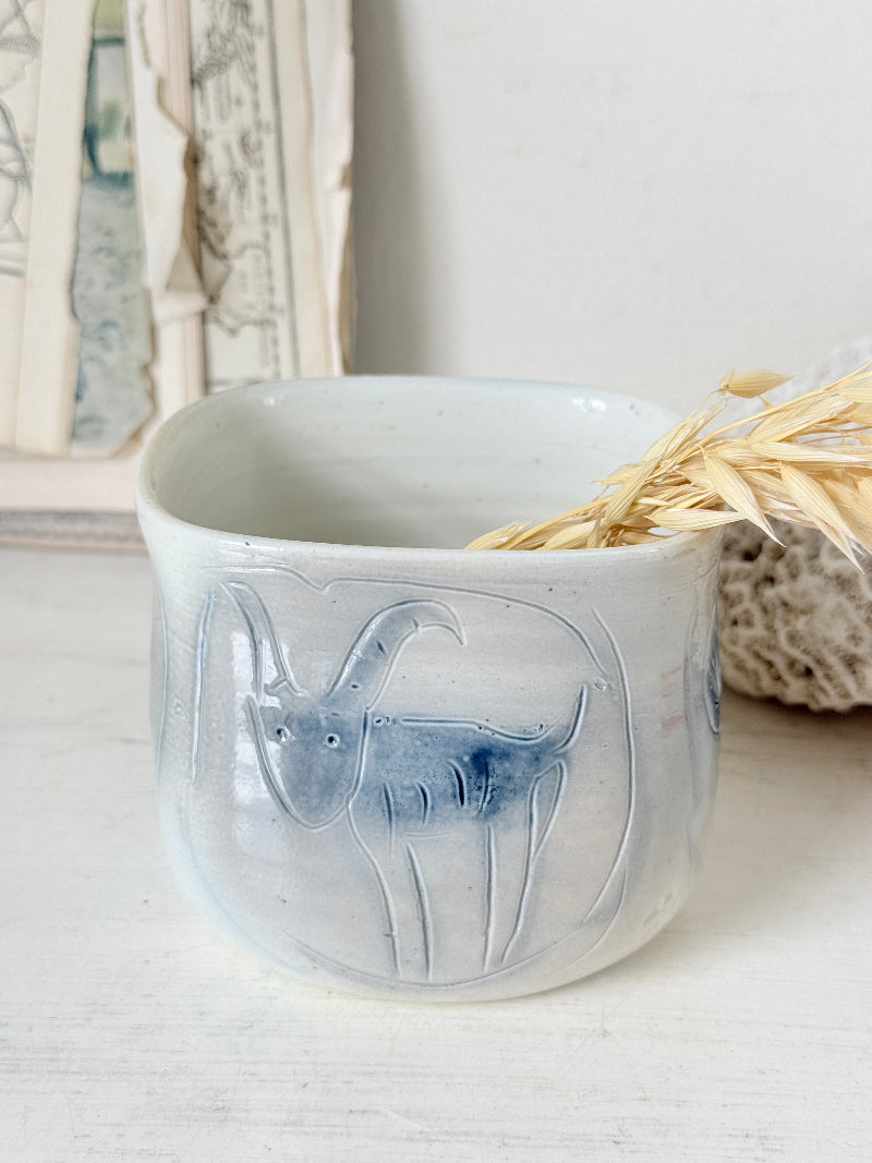 Hand painted ceramic pot with blue ram motif, pale grey off white glaze and handmade decorative form