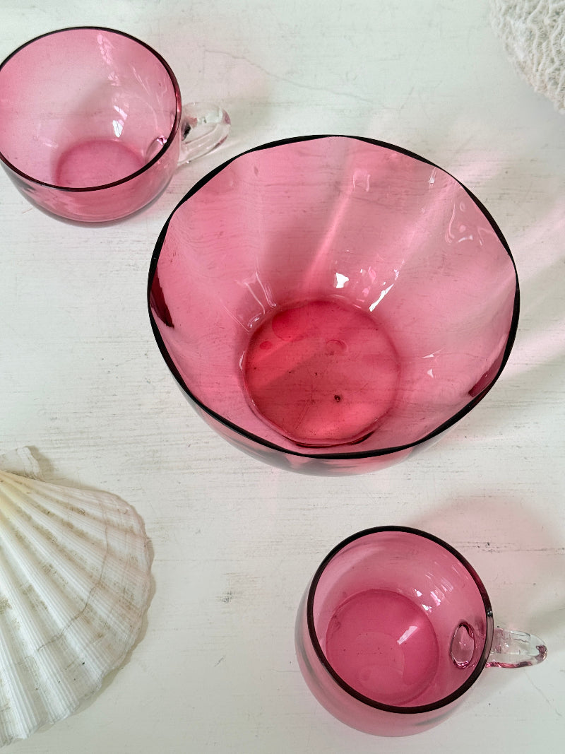 Trio of antique cranberry glass with sugar bowl, teacup, coffee can, clear glass handles and deep pink glass