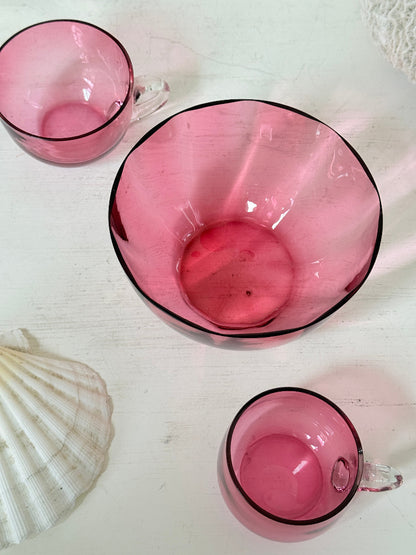 Trio of antique cranberry glass with sugar bowl, teacup, coffee can, clear glass handles and deep pink glass