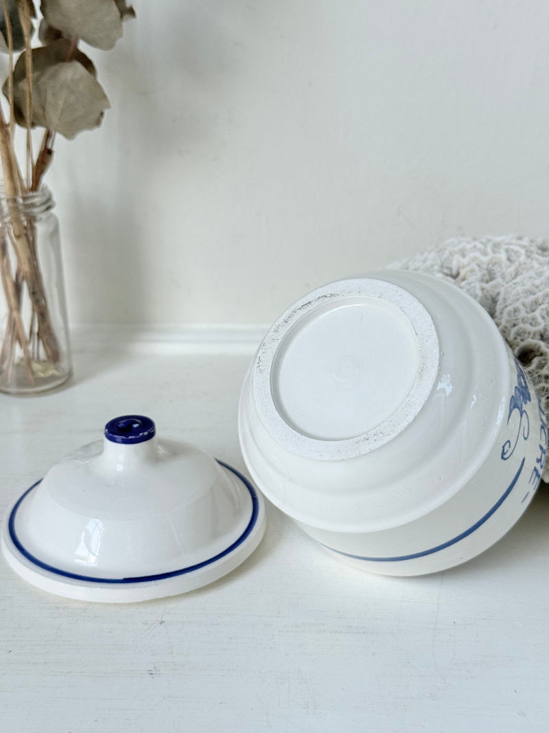 Vintage French blue and white studio pottery sugar bowl with lid, photographed on a white surface.