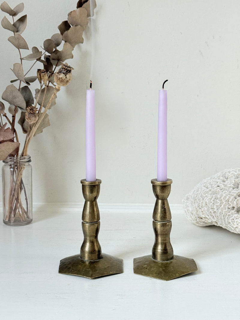 Pair of miniature brass candlesticks with hex bases photographed on a white surface