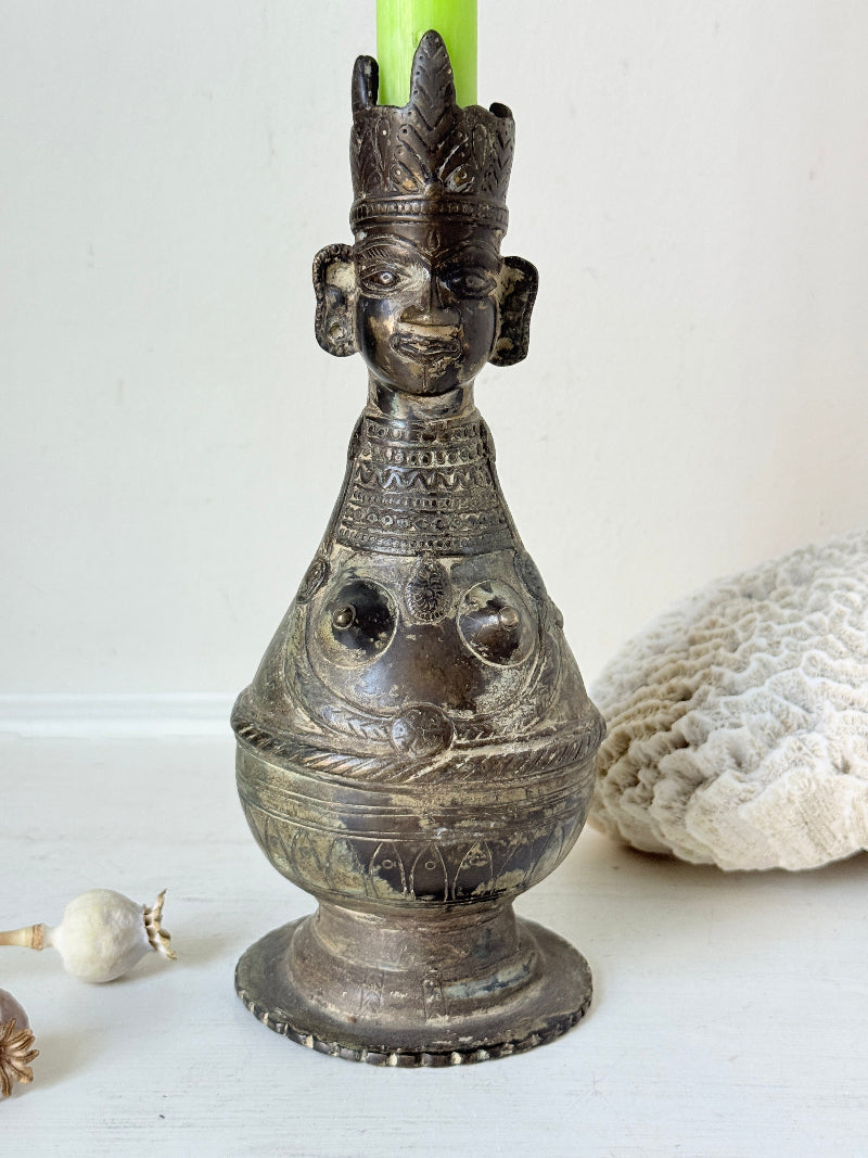 Antique Bengali anthropomorphic brass ritual vessel with goddess figure and lobed headdress, on a white surface