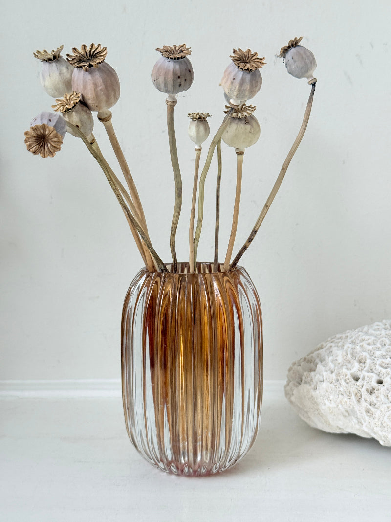 Vintage ribbed amber brown glass vase photographed on a white surface