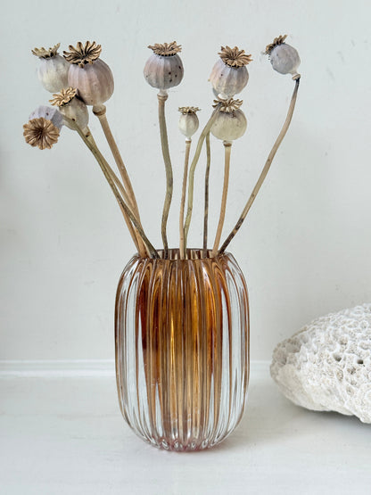 Vintage ribbed amber brown glass vase photographed on a white surface