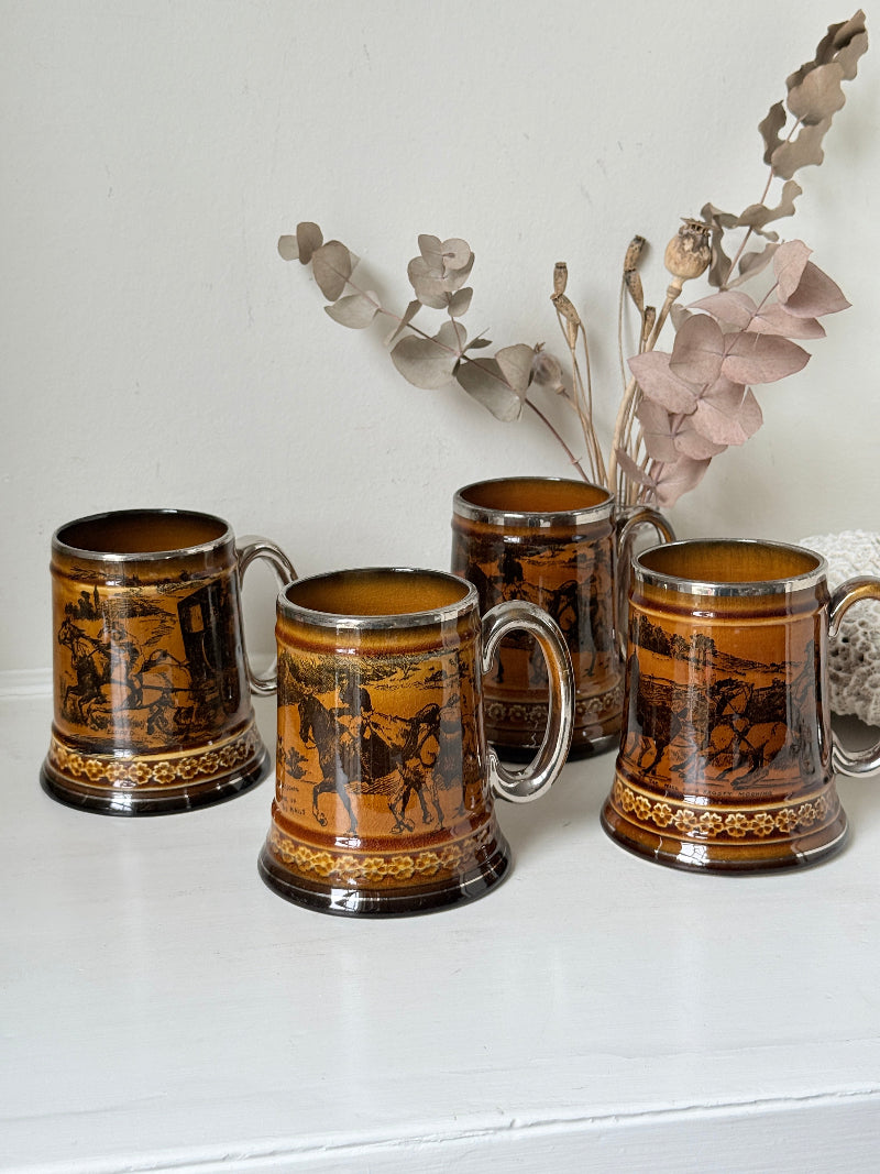 Set of 4 antique Ridgway stoneware beer tankards photographed on a white surface in amber treacle glaze with black Coaching Days and Coaching Ways scenes