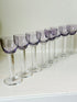 Set of 8 vintage lilac tinted liqueur glasses on a white surface