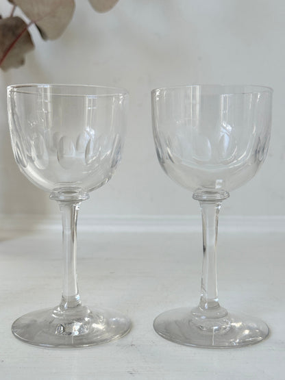 Set of 5 vintage clear glass liqueur glasses with small stems photographed on a white surface