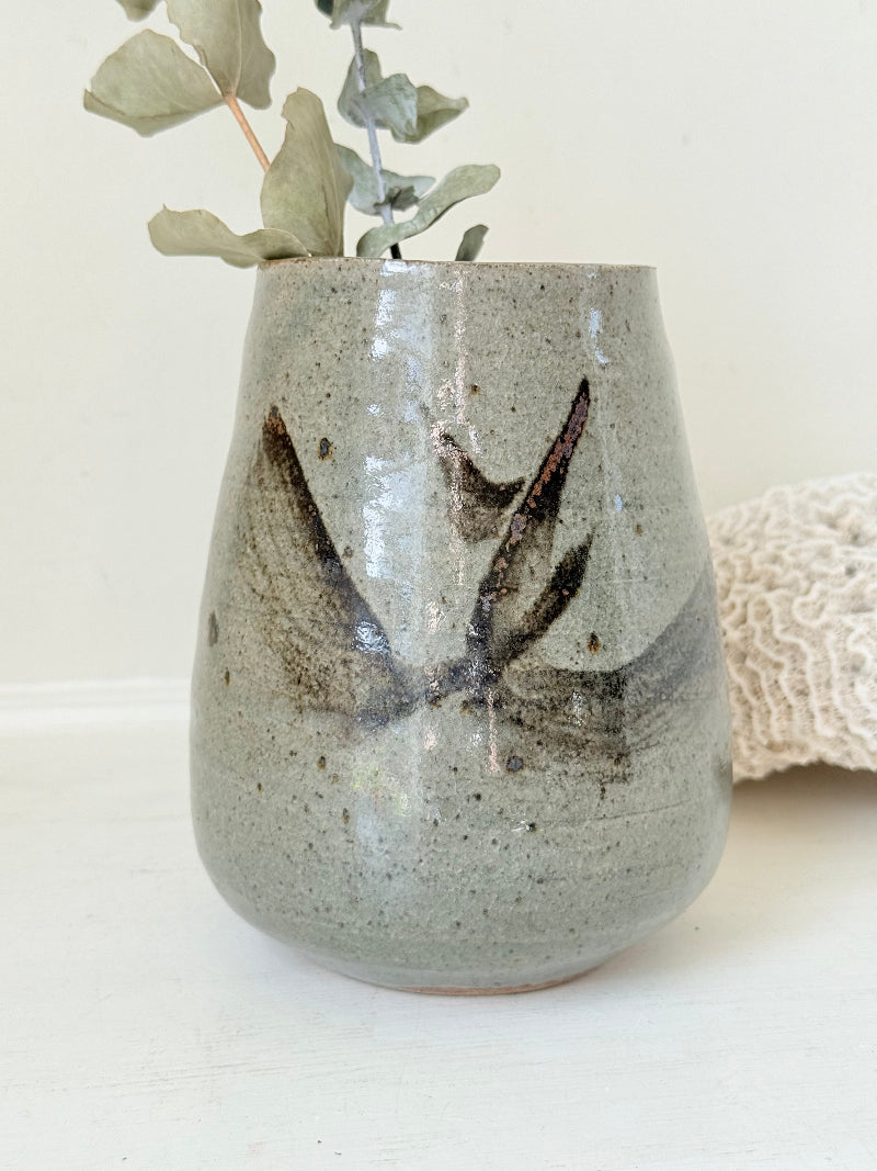 Hand thrown studio pottery vase with ash glaze and brushstroke motif, photographed on white surface