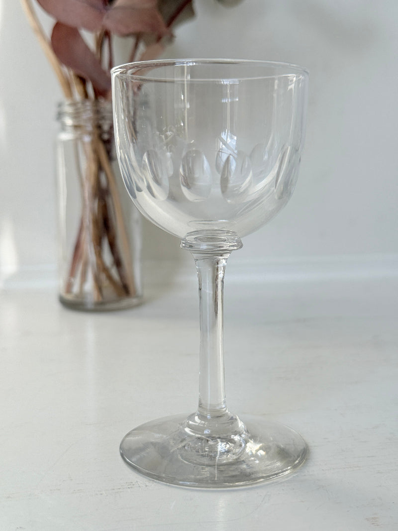 Set of 5 vintage clear glass liqueur glasses with small stems photographed on a white surface