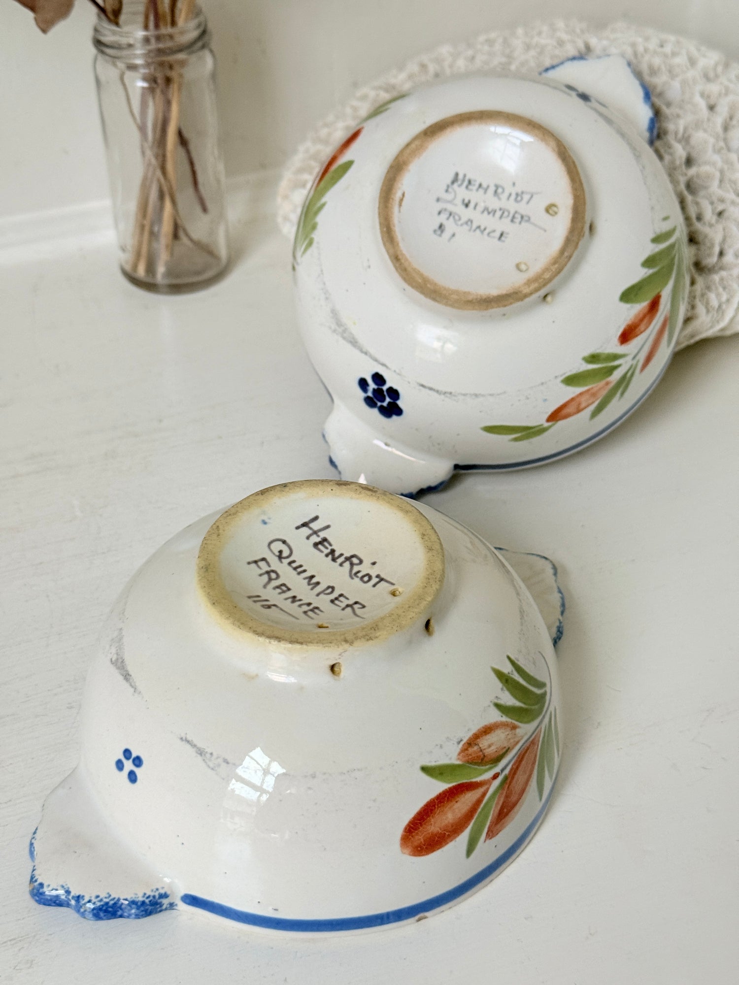 Pair of vintage French Quimper Breton figure bowls with blue handles, photographed on a white surface