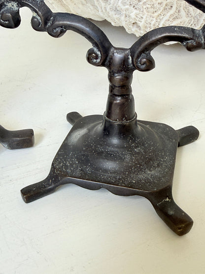 Pair of vintage brass three arm candelabra with scrolling arms and aged patina, photographed on a white surface