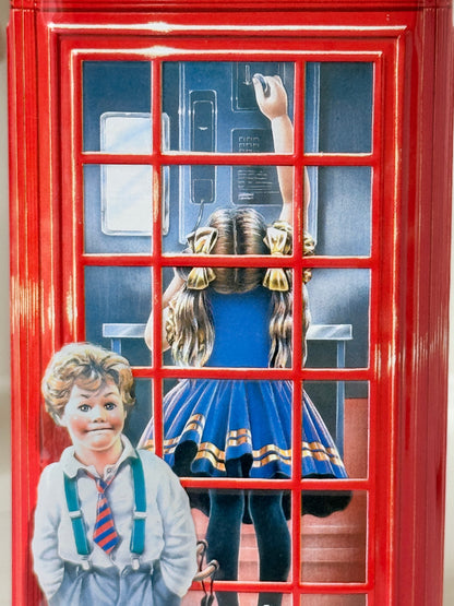 Vintage red telephone box tin money box on a white surface