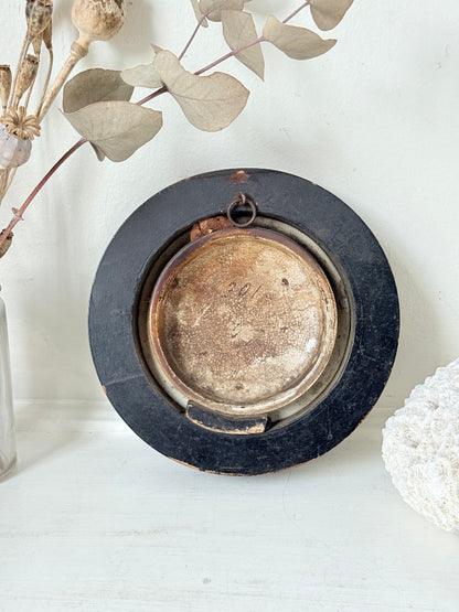 Antique Prattware framed ceramic lid with rural family scene photographed on a white surface.