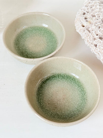 Pair of sage green Thai celadon olive bowls with crackled glaze, photographed on white surface