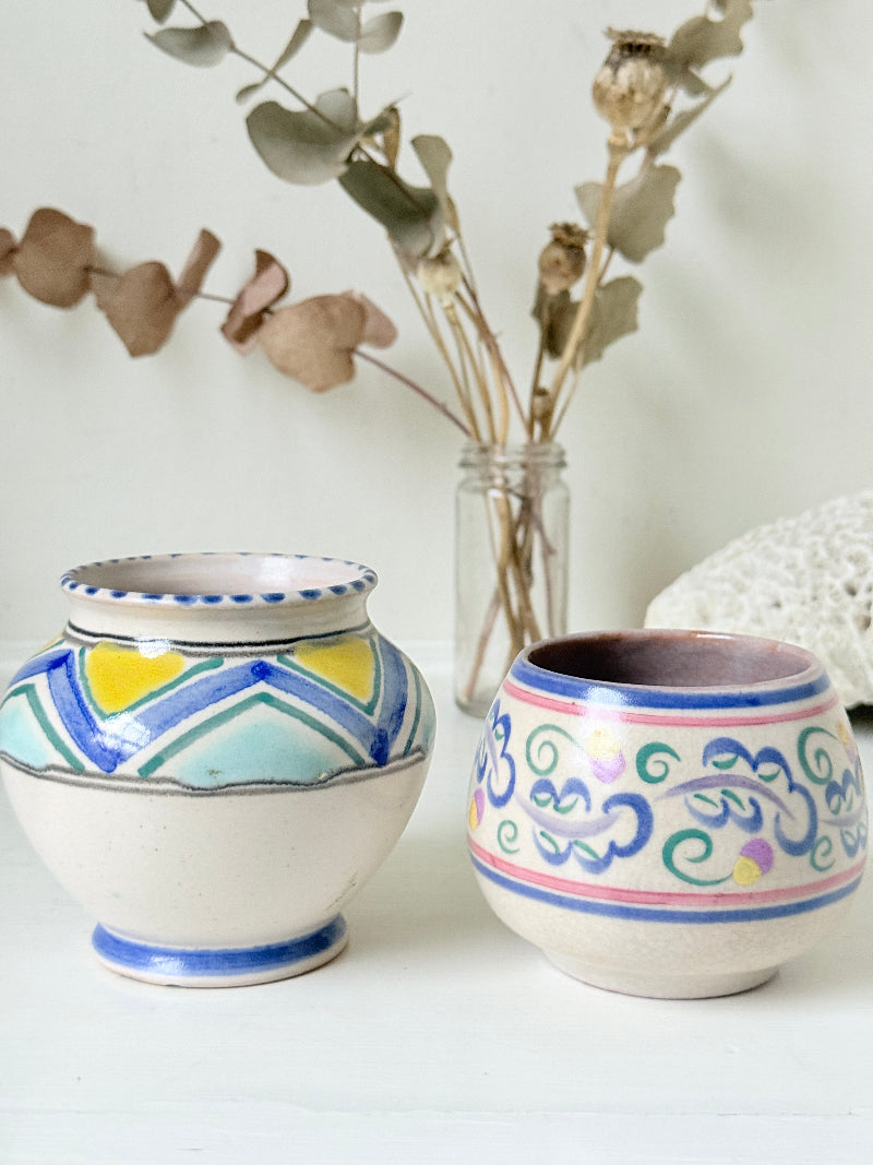 Pair of vintage studio pottery pots in blue green and pink glaze photographed on a white surface