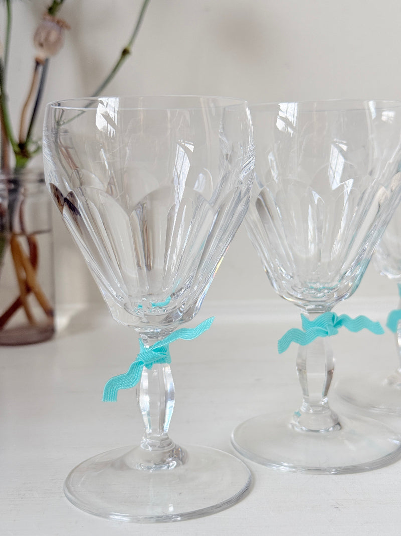 Set of four vintage cut crystal aperitif glasses with faceted bowls, photographed on a white surface