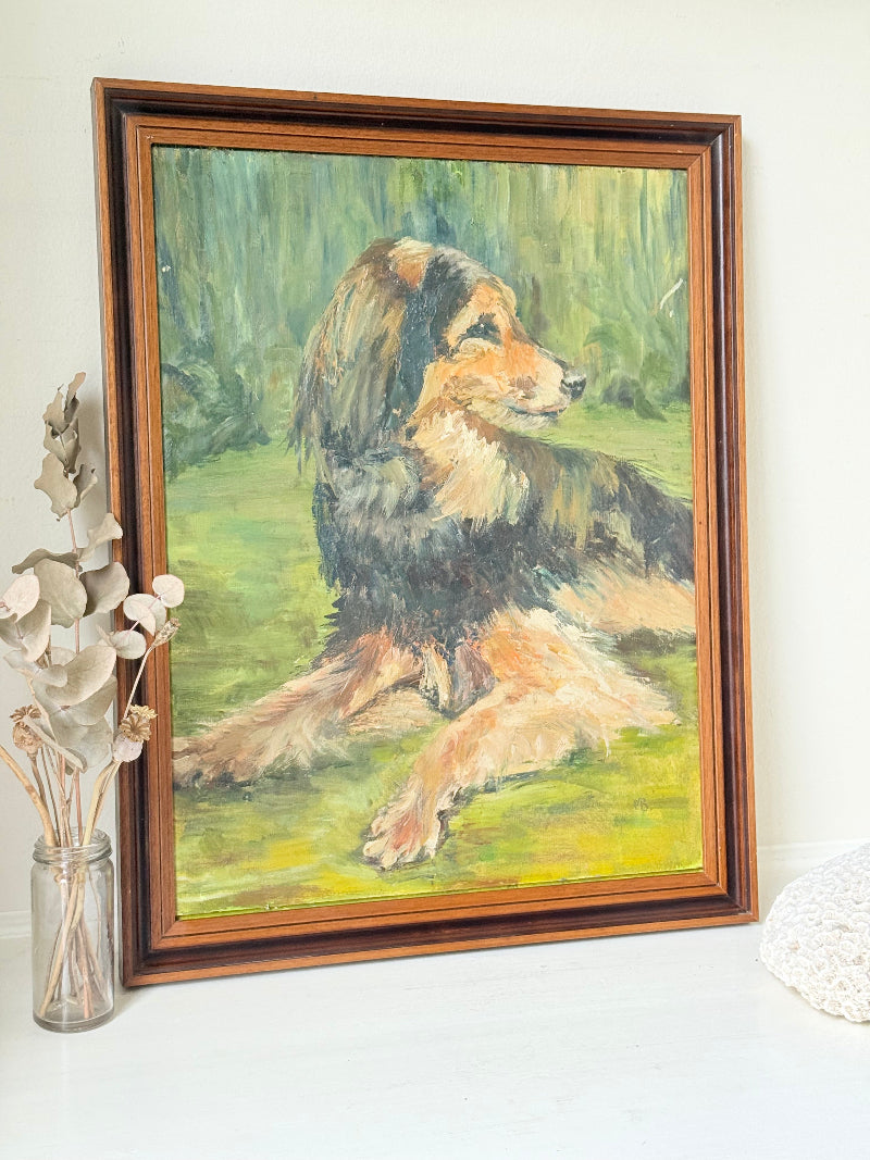 Oil painting of a dog by Muriel Hester Broughton in wooden frame, photographed on white surface.