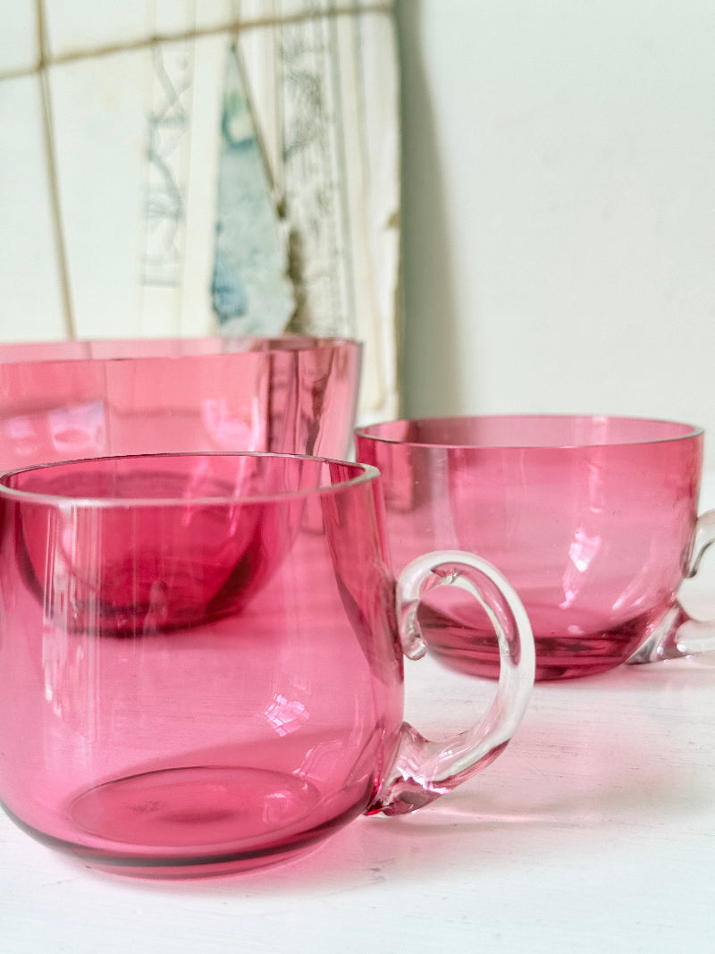 Trio of antique cranberry glass with sugar bowl, teacup, coffee can, clear glass handles and deep pink glass