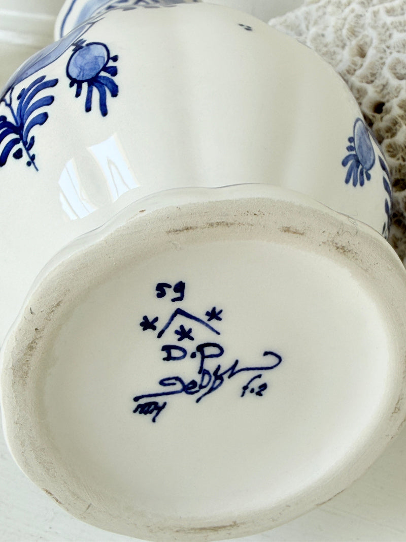 Vintage Delft style blue and white pottery vase with hand painted floral decoration, photographed on a white surface