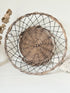 Vintage wicker and wire basket with woven base photographed on a white surface