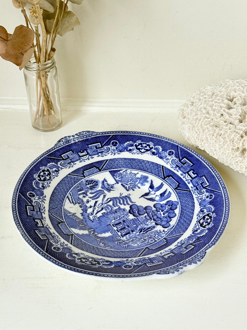 Blue Willow serving plate with cobalt blue transfer pattern shown on a white surface.