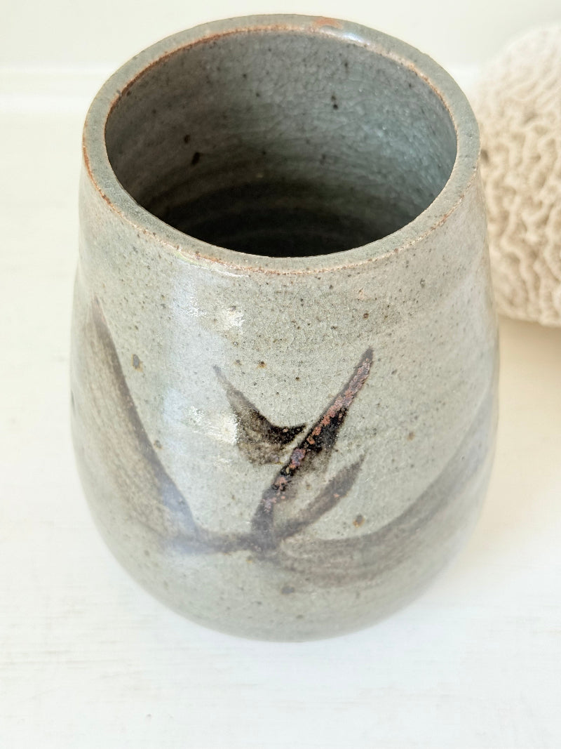 Hand thrown studio pottery vase with ash glaze and brushstroke motif, photographed on white surface