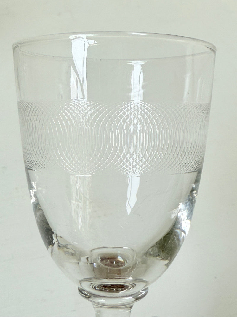 Set of six vintage etched clear glasses with decorative banding, one with a tiny rim chip, photographed on white surface.