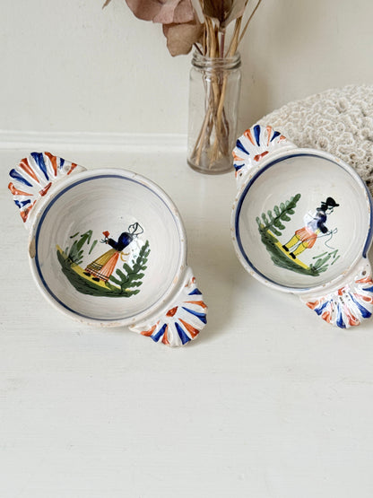 Pair of vintage French Quimper olive bowls with Breton figure and fan handles, photographed on a white surface