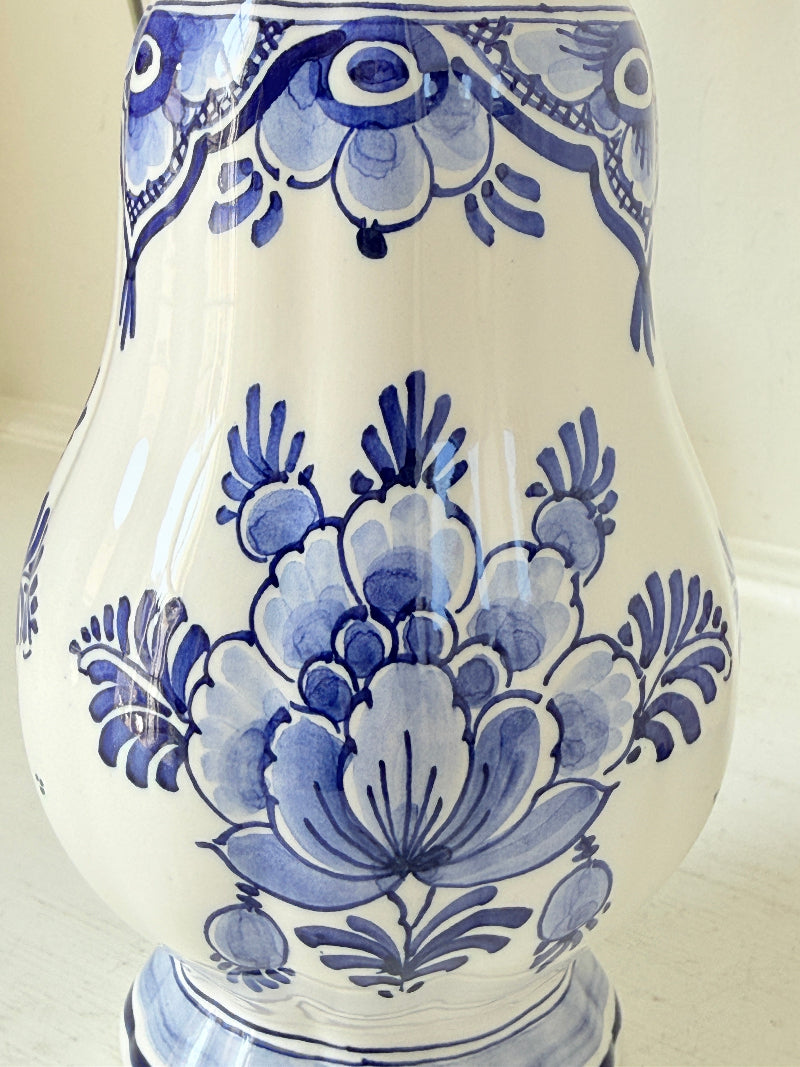Vintage Delft style blue and white pottery vase with hand painted floral decoration, photographed on a white surface
