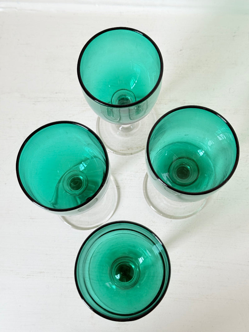 Antique set of four Bristol green liqueur glasses with clear stems, photographed on a white surface